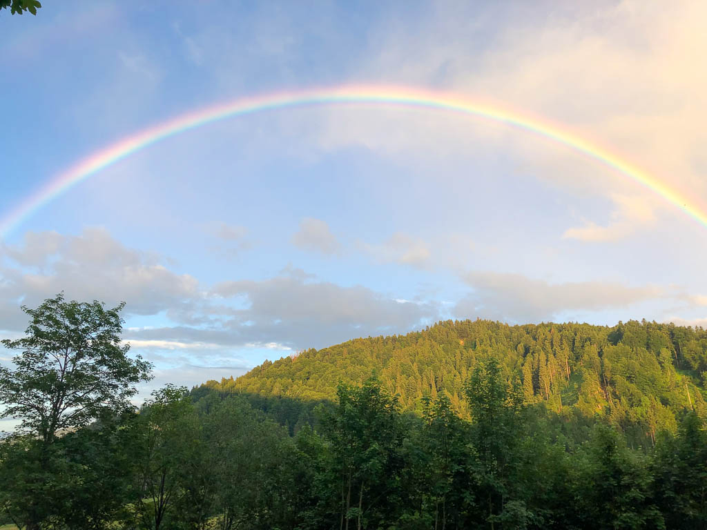 Regenbogen über den Hügeln einer anmutigen Landschaft